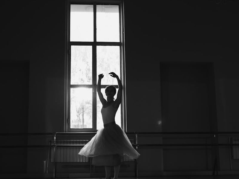 Person practicing slow movements in a bright airy studio.